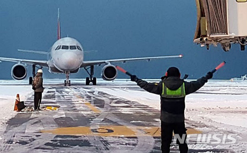 【제주=뉴시스】우장호 기자 = 제주국제공항 계류장에서 여객기가 지상조업 직원의 유도를 받으며 탑승교에 진입하는 모습. 2018.02.05. (사진=한국공항공사 제주지역본부 제공)woo1223@newsis.com