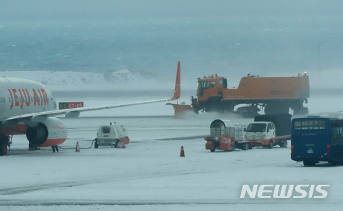 【제주=뉴시스】우장호 기자 = 한때 강설로 제주공항 활주로가 폐쇄된 가운데 지난 6일 제주국제공항 활주로에 제설차가 부지런히 눈을 치우고 있다. 2018.02.06.woo1223@newsis.com