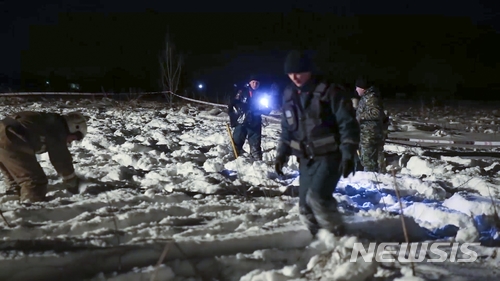 【 AP/뉴시스】러시아 도모데도보 공항에서 푸켓행 여객기 한 대가 12월 2일 (현지시간) 엔진 한쪽 화재로 긴급 회항, 착륙했다고 공항 당국이 발표했다. 사진은 2018년 2월 11일 공항 직원들이 안토노프(An)-148 여객기의 탑승객 71명이 모두 사망한 이 공항의 추락현장을 조사하는 장면. 2025. 12. 04.  