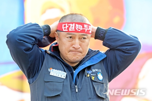  【군산=뉴시스】고석중 기자 = 14일 전북 군산시 한국지엠 군산공장에서 열린 '군산공장 폐쇄 저지를 위한 전 직원 결의대회'에서 김재홍 전국금속노동조합 한국지엠지부 군산지회장이 삭발식을 한 뒤 머리띠를 묶고 있다. 2018.02.14일(사진=한국지엠 노조 제공) photo@newsis.com 