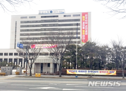  【군산=뉴시스】고석중 기자 = 18일 전북 군산시청 청사에 '한국GM 군산공장 폐쇄 결정을 철회하라'는 대형 현수막이 걸려있다. 지엠은 지난 13일 "오는 5월 말까지 군산공장의 차량 생산을 중단하고 공장을 폐쇄하기로 했다"고 밝힌 바 있다. 군산시는 "이번 조치로 1만여 가구 4만여 명이 넘는 인구가 생계 위기상황에 빠지는 심각한 상황에 몰릴 수 있다"고 내다봤다. 2018.02.18.&nbsp; k9900@newsis.com 