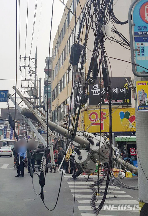 【부산=뉴시스】 하경민 기자 = 19일 오후 2시 32분께 부산 금정구 부곡시장 사거리에서 건설현장 고철을 싣고 가던 22t 트럭의 적재물이 전선이 걸리는 바람에 전신주 2개가 쓰러지는 사고가 났다. 2018.02.19. (사진=부산경찰청 제공)yulnetphoto@newsis.com