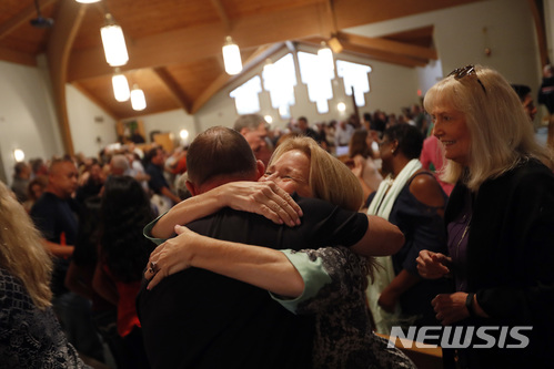 【 코랄 스프링스=AP/뉴시스】미국 플로리다주 코랄 스프링스에 있는 퍼스트 유나이티드 감리교회에서 18일(현지시간) 신도들이 마저리 스톤맨 더글러스 고등학교 총기난사 희생자들을 위한 예배를 들인 후 서로 포옹하고 있다. 2018.2.19 