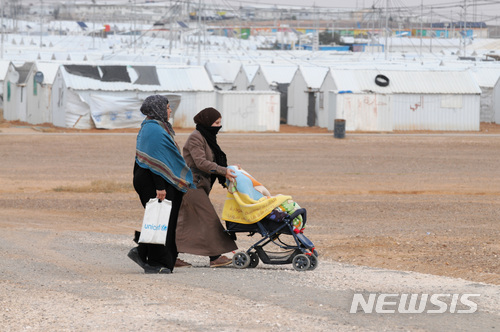【아즈락(요르단)=뉴시스】 채정병 기자 = 18일(현지시간) 요르단 아즈락 시리아 난민캠프에 난민들을 위한 일자리센터가 문을 연 가운데 난민 여성이 유모차를 끌고 캠프 내를 이동하고 있다. 국제노동기구(ILO)와 국제난민기구(UNHCR)는 요르단과 네덜란드 정부의 지원으로 캠프 거주 난민들에게 농업, 건축분야 등에서 취업기회를 제공하게 된다. 요르단 정부는 시리아 사태의 장기화로 인해 갈수록 줄어드는 국제사회 지원에 대한 대안으로 2016년부터 지금까지 시리아 난민들에게 8만 7천 건이 넘는 노동허가증을 발급했고, 이들 난민들은 수도 암만을 비롯한 도시와 마을 등지에서 합법적인 경제활동을 하고 있다.유엔난민기구(UNHCR)에 따르면 요르단 내 등록 시리아 난민은 2018년 2월 현재 657,628명으로 파악되고 있다. 2018.02.19.chae0191@newsis.com