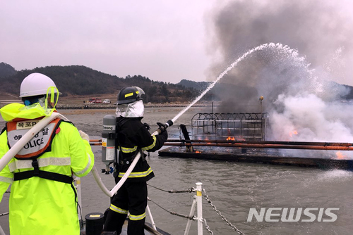 【목포=뉴시스】박상수 기자 = 목포해경이 19일 오후 전남 신안군 지도읍 참도선착장 앞 해상에 정박 중이던 바지선에서 발생한 화재를 진화하고 있다. 2018.02.19. (사진=목포해경 제공) photo@newsis.com