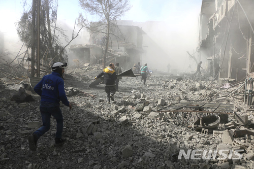 【구타=AP/뉴시스】 20일 시리아 수도 동쪽 반군 장역 지역인 동 구타에서 정부군의 무자비한 공습과 포격에 사람들이 도망가고 있다. 이날 100명 넘게 사망한 것으로 파악된 이곳은 2013년부터 반군과 함꼐 40만 명의 시민들이 정부군의 포위로 인한 극심한 물자 부족을 견디며 살아왔다. 사진은 시리아인 자체 조직인 화이트 헬멧이 제공했다. 2018. 2. 20
