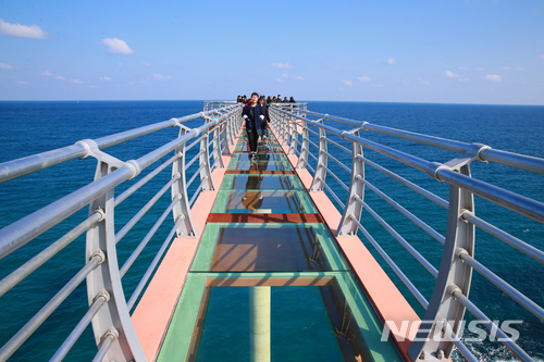 【울진=뉴시스】강진구 기자 = 경북 울진군(군수 임광원)은 올해 울진대게 및 붉은대게 축제기간 동안 후포를 방문하는 관광객들에게 선보이기 위해 후포 등기산 스카이워크를 임시 개장한다고 26일 밝혔다.사진은 이날 개장한 후포 스카이워크를 걷고 있는 관광객.2018.02.26.(사진=울진군 제공) photo@newsis.com