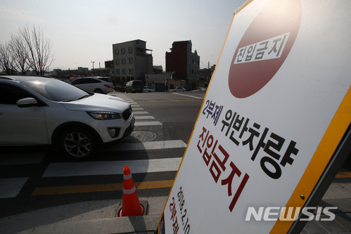 [강릉=뉴시스]김경목 기자 = 교통통제요원이 지난 2018년 2월25일 강원 강릉시 교2동 지역에서 2부제 위반차량을 단속하고 있는 모습. 2018.02.26. photo31@newsis.com