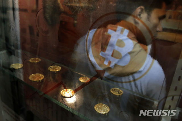 【홍콩=AP/뉴시스】2017년 12월8일 홍콩에서 한 남성이 비트코인 현금자동입출금기(ATM) 앞에 서 있다. 2019.06.04. 