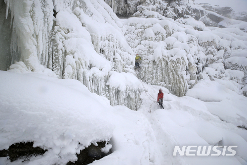 【더비셔(영국)=AP/뉴시스】한 빙벽 등반가가 1일 영국 북부 더비셔에 있는 하이파크의 얼어붙은 킨더 폭포 앞에 서 있다. 유럽 전역에 몰아닥친 시베리아 강추위가 몰고온 폭설로 이날 영국과 프랑스, 스위스의 공항들이 폐쇄되고 수많은 차량들이 눈 속에서 도로에 고립돼 꼼짝 못했다. 2018.3.1