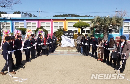 【제주=뉴시스】조수진 기자 = 2일 오전 제주시 애월읍 더럭초등학교의 본교 승격 기념식에서 현판 제막식이 열리고 있다. 이곳은 학생 수 감소로 인해 지난 1996년 더럭국민학교에서 애월초 더럭분교가 됐다가 지역 주민들의 학교 살리기 노력으로 지난 2010년부터 학생이 꾸준히 늘기 시작했다. 지난 2012년 한 기업 이미지 광고를 통해 알록달록 무지갯빛 학교로 널리 알려졌다. 2018.03.02. susie@newsis.com
