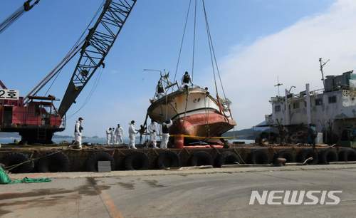 【서울=뉴시스】해경은 3일 오전 2시 41분께 경남 거문도 해상에서 바지선에 인양한 근룡호를 11:40분께 완도해경 전용부두에 계류하고 선체 고정을 마치는 한편 드론 등을 동원해 수색작업을 벌이고 있다.이어 사고원인 규명을 위해 선체 정밀수색과 함께 해경, 해난심판원, 국립과학수사연구소, 선박안전기술공단 등 4개 기관이 참여하는 합동 정밀감식에 들어갔다. 2018.03.03. (사진=환도해경 제공) photo@newsis.com