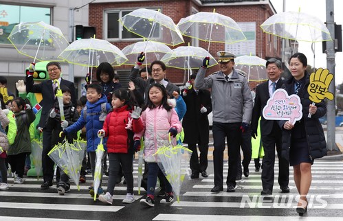 【서울=뉴시스】고승민 기자 = 8일 오전 서울 청운초등학교 앞에서 도로교통공단 주최로 열린 '우리 아이 스쿨존, 사랑으로 지켜주세요-스쿨존 교통사고 제로 캠페인'에서 초등학생들이 여경, 녹색어머니회원 및 이철성 경찰청장과 조희연 서울시교육감 윤종기 도로교통공단 이사장 등 내빈들의 도움을 받으며 횡단보도를 건너고 있다. 2018.03.08. kkssmm99@newsis.com