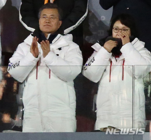 【평창=뉴시스】김경목 기자 = 2018평창동계패럴림픽대회 개막일인 9일 오후 강원 평창군 대관령면 평창올림픽스타디움에서 열린 개회식 성화대 점화 순서에서 장애인아이스하키 주장 한민수가 성화를 전달받아 등에 성화를 매고 줄 하나에 의지해 경사진 슬로프를 오르는 모습에 감동한 김정숙 여사가 눈물을 훔치고 문재인 대통령은 격려의 박수를 치고 있다. 2018.03.09.&nbsp; photo31@newsis.com 