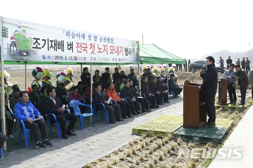 【순천=뉴시스】김석훈 기자 = 전남 순천시는 12일 해룡면 신대리 신성마을 백인기(51)농민의 0.3㏊ 논에서 농업인, 공무원, 농협관계자 등 100여명이 참석한 가운데 올해 전국 첫 노지 모내기를 실시했다고 밝혔다. 2018.03.12. (사진=순천시청 제공)  kim@newsis.com