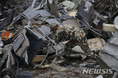 【카트만두=AP/뉴시스】네팔 카트만두 공항 인근에 12일(현지시간) 오후 방글라데시 항공사 소속 여객기가 추락해 최소 40명이 사망하고 23명이 다친 가운데 구조대원이 잔해를 수색하고 있다. 2018.03.12