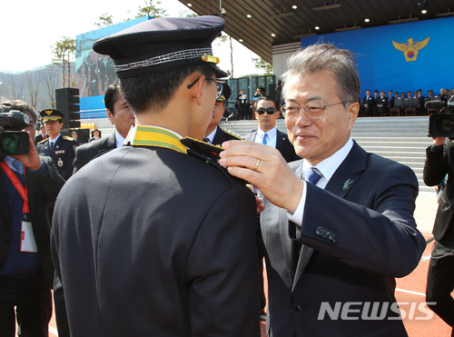 【아산=뉴시스】전신 기자 = 문재인 대통령이 13일 충남 아산 경찰대학에서 열린 2018 경찰대학생 및 간부후보생 합동임용식에서 신임 임용 간부들에게 계급장을 달아주고 있다. 2018.03.13. photo1006@newsis.com