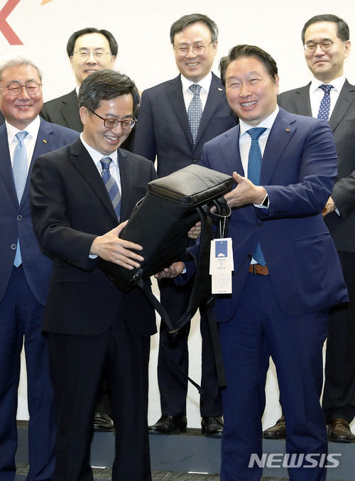 【서울=뉴시스】최동준 기자 = 김동연 경제부총리 겸 기획재정부 장관이 14일 서울 종로구 SK 본사에서 간담회 전 최태원 SK 회장에게 SK 이노베이션에서 후원한 사회적기업 백팩을 전달 받고 있다. 이날 간담회는 문재인 정부의 혁신성장, 일자리 창출 등 정책방향을 설명하고 SK의 적극적인 협조를 요청할 예정이다. 2018.03.14.&nbsp; photocdj@newsis.com