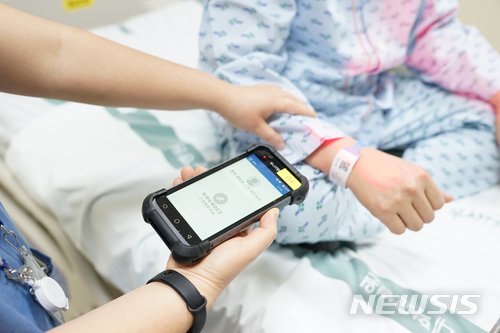 【부산=뉴시스】 제갈수만 기자 = 부산대학교병원(병원장 이창훈)은 최근 스마트 기기를 활용한 환자안전관리 시스템을 구축해 운영에 들어갔다고 15일 밝혔다. 사진은 간호사가 환자 손목에 부착된 바코드와 주사기의 바코드를 기기에 인식해 환자의 처방정보를 확인하고 있다.2018.03.15. (사진= 부산대병원 제공) photo@newsis.com