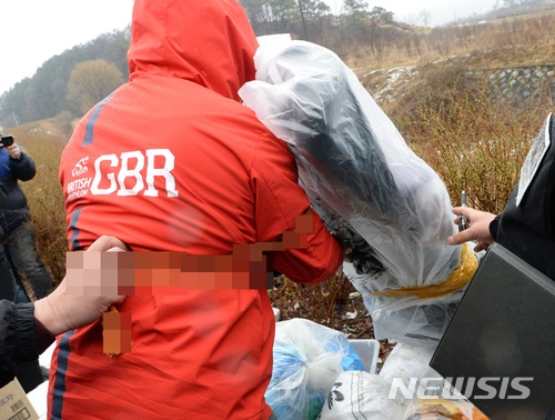 【전주=뉴시스】강인 기자 = 21일 경찰이 전북 전주에서 동료 환경미화원을 살해한 이모(50)씨에 대한 현장 검증을 진행하는 가운데 이씨가 동료를 살해한 뒤 쓰레기 더미에 유기하는 모습을 재연하고 있다. 2018.03.21 kir1231@newsis.com