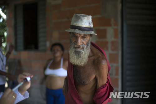 【카시미로 데 아브류(브라질)=AP/뉴시스】2017년 3월17일 브라질 카시미로 데 아브류에서 한 노인이 황열병 예방백신 접종을 받기 위해 셔츠를 걷어 팔을 드러내 보이고 있다. 히카르도 바호스 브라질 보건장관은 20일(현지시간) 황열병 예방백신 접종 의무화를 전국으로 확대한다고 발표했다. 브라질에서는 지난해 7월 이후 920명의 황열병 환자가 발생해 이중 300명이 숨졌다. 2018.3.21