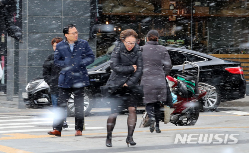 【서울=뉴시스】이영환 기자 = 절기상 춘분(春分)이자 눈이 내린 21일 오후 서울 종로구 세종문화회관 앞에서 한 시민이 눈을 맞으며 걸어가고 있다. 2018.03.21.&nbsp; 20hwan@newsis.com