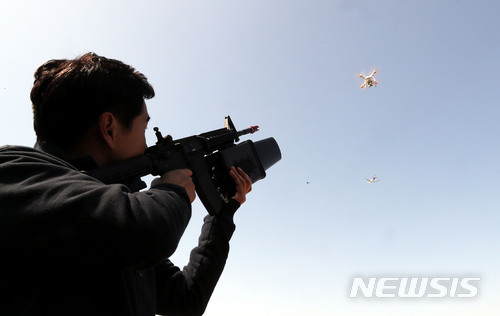 【인천공항=뉴시스】홍찬선 기자 = 22일 오후 인천 중구 영종도 조류 서식지에서 인천공항 조류퇴치 전담팀원이 무단으로 침투한 드론(무인비행장치)을 제밍건(무선전파로 미허가 드론의 침투를 방지하는 장치)을 이용해 착륙시키고 있다. 이날 인천공항공사에 따르면 시속 370km로 운항하는 항공기에 900g의 조류 한마리가 충돌할 경우 항공기가 받는 순간 충격은 4.8t에 이른다. 최근 4년간 국내에서만 900건에 달하는 버드 스트라이크 사고가 발생했다. 이에 따라 전세계 공항에서는 버드 스트라이크를 조류퇴치 전담반을 운영하고 폭음탄, 경보기, 공항 주변 습지 제거 등 예방법을 동원하고 있다. 2018.03.22. mania@newsis.com