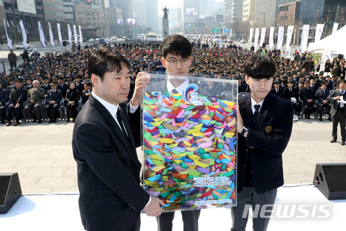【서울=뉴시스】박진희 기자 = 지난해 서울 종로구 광화문광장에서 열린 제3회 서해수호의 날 기념식에 참석한 북한의 서해 북방한계선(NLL) 도발에 맞서 생명을 바친 장병들의 후배들이 직접 만든 종이배를 유가족에게 전달하고 있다.서해수호의 날은 제2연평해전과 천안함 피격, 연평도 포격 등 북한의 도발에 맞서 나라를 위해 목숨 바친 호국영웅들을 추모하기 위해 제정한 법정기념일이며, 매년 3월 네번째 금요일이다. 2018.03.23.pak7130@newsis.com
