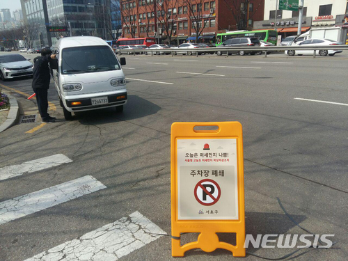 【서울=뉴시스】 서울형 고농도 미세먼지 비상저감조치가 시행된 26일 서울 서초구가 구청 주차장 폐쇄에 따른 안내판을 세웠다. 구청 관계자가 방문객들에게 인근 주차장으로 안내하고 있다. 2018.03.26. (사진=서초구 제공) photo@newsis.com