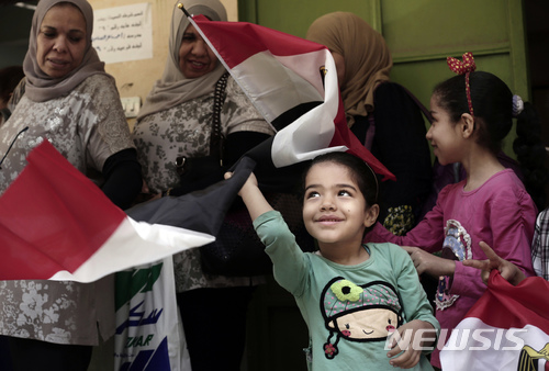 【카이로=AP/뉴시스】26일(현지시간) 이집트 대선 첫날 카이로의 한 투표소에서 이집트 여성들과 어린이들이 국기를 흔들고 있다. 2018.3.27.