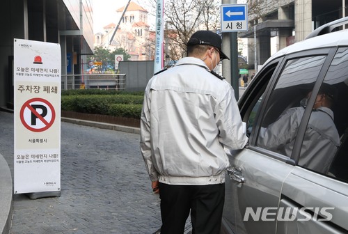 【서울=뉴시스】조성봉 기자 = 서울을 비롯한 수도권에 미세먼지 비상저감조치가 내려진 27일 오전 서울 중구 서울시청 주차장 입구에서 보안요원이 차량을 통제하고 있다. 2018.03.27.suncho21@newsis.com