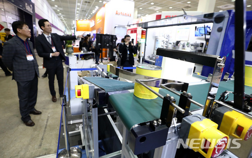 【서울=뉴시스】이영환 기자 = 28일 오후 서울 강남구 코엑스에서 열린 2018 스마트공장·자동화산업전을 찾은 관람객이 자동화 설비를 살펴보고 있다.2018 스마트공장·자동화산업전은 480개사가 참가하며 30일까지 코엑스 A, B, C홀에서 열린다. 2018.03.28.&nbsp;&nbsp; 20hwan@newsis.com