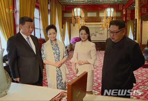 【서울=뉴시스】 북한 조선중앙TV가 29일 방중한 김정은 노동당 위원장과  부인 리설주가 시진핑 중국 국가주석과 부인 펑리위안 여사에게 자신들이 준비한 선물을 소개하는 모습을 공개하고 있다. 2018.03.29.(사진=조선중앙TV 캡처) photo@newsis.com