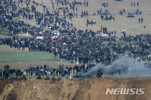 【가자=AP/뉴시스】 30일 가자지구 봉쇄선 행진시위에 나선 팔레스타인 사람들이 몰려들자 펜스 앞의 이스라엘 병사들이 긴장하고 있다. 2018. 3. 30.
