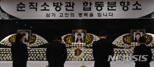 【아산=뉴시스】함형서 기자 = 동료 소방관들이30일 오후 동물포획을 하다 숨진 소방관 3명의 시신이 안치된 충남 아산시 온양 장례식장에 합동분향소에서 헌화 및 묵념을 하고 있다. 2018.03.30.