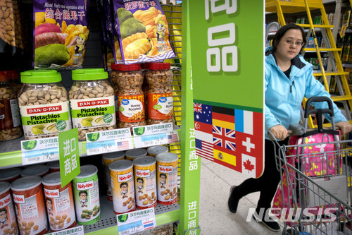 【베이징=AP/뉴시스】지난 3월23일 중국 베이징의 한 슈퍼마켓에서 여성 1명이 미국산 수입 견과류들이 진열된 전시대 옆을 카트를 밀고 지나가고 있다. 중국은 2일 약 30억 달러 상당의 미국산 돼지고기와 과일 등 농축산물에 높은 관세를 부과했다. 2018.4.2