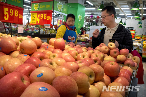 【베이징=AP/뉴시스】지난 3월23일 중국 베이징의 한 슈퍼마켓에서 미국 회사 로고가 붙은 유니폼을 입은 여성 직원 1명이 고객의 미국산 과일 쇼핑을 돕고 있다. 중국은 2일 약 30억 달러 상당의 미국산 돼지고기와 과일 등 농축산물에 높은 관세를 부과했다. 2018.4.2 
