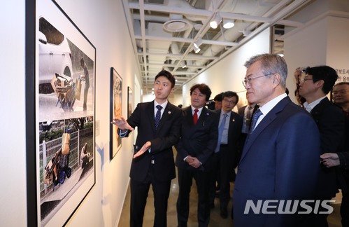 【서울=뉴시스】전진환 기자 = 문재인 대통령이 2일 오후 서울 종로구 세종문화회관 미술관에서 열린 제54회 한국보도사진전을 찾아 이동희 한국사진기자협회장의 안내로 전시된 사진을 관람하고 있다.&nbsp; 1년에 단 한 번 열리는 한국보도사진전은 올해로 54회를 맞았으며 '하나된 열정, 모두의 불꽃'이란 주제로 지난 달 21일부터 3일까지 세종문화회관 미술관에서 열리고 있다. 2018.04.02.&nbsp; amin2@newsis.com