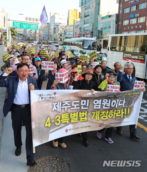 【제주=뉴시스】우장호 기자 = 제주 4·3 추념일을 하루 앞둔 2일 오후 제주시청 앞 도로에서 제주 4·3 유족 및 도민 1000여명이 4·3 특별법 개정 촉구 구호를 외치며 행진하고 있다. 2018.04.02. woo1223@newsis.com