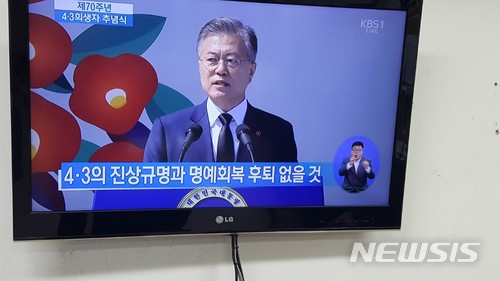 【제주=뉴시스】강정만 기자 = 문재인 대통령이 3일 오전 제주4·3평화공원에서 열린 제70주년 4·3희생자 추념식에 참석해 추념사를 하는 모습이 TV로 제주도내 곳곳으로 중계방송되고 있다. 2018.04.03 kjm@newsis.com