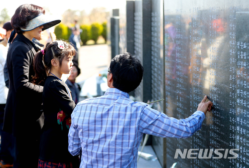 【제주=뉴시스】우장호 기자 = 제주 4·3 추념식이 열리는 3일 오전 제주시 봉개동 4·3 평화공원 내 각명비에 4·3 유족이 찾아와 어린 딸에게 희생자 이름이 새겨진 비석을 가리키고 있다. 2018.04.03. woo1223@newsis.com