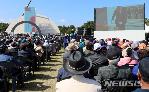 【제주=뉴시스】우장호 기자 = 3일 오전 제주시 봉개동 4·3 평화공원 내 위령제단에서 문재인 대통령이 분향하고 있는 가운데 4·3 유족들이 대형 화면으로 지켜보고 있다. 2018.04.03.&nbsp; woo1223@newsis.com