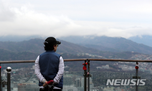 [서울뉴시스]이영환 기자 =서울 용산구 N서울타워를 찾은 한 시민이 구름 낀 하늘을 바라보고 있다. 2018.04.04. 20hwan@newsis.com