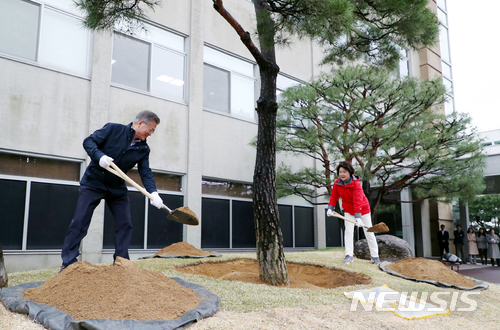 【서울=뉴시스】문재인 대통령과 부인 김정숙 여사가 5일 오전 제73회 식목일을 맞아 청와대 여민관 앞 화단에 소나무 기념식수를 하고 있다. 2018.04.05. (사진=청와대 제공) photo@newsis.com