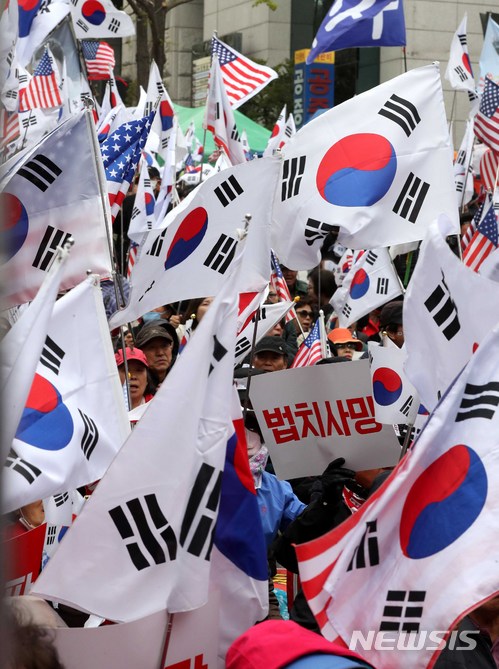 【서울=뉴시스】고범준 기자 = 박근혜 전 대통령에 대한 1심 선고가 열리는 6일 오후 서울 서초구 서울중앙지방법원 앞에서 박 전 대통령 지지자들이 태극기를 흔들며 무죄와 석방을 촉구하는 집회를 하고 있다. 2018.04.06. bjko@newsis.com