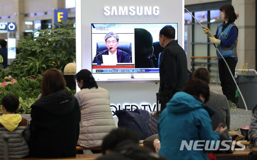 【인천공항=뉴시스】홍찬선 기자 = 박근혜 전 대통령의 국정농단 1심 선고가 시작된 6일 오후 인천공항 제1여객터미널 입국장에서 시민들이 TV 생중계를 주의깊게 보고 있다. 2018.04.06.&nbsp;&nbsp; mania@newsis.com