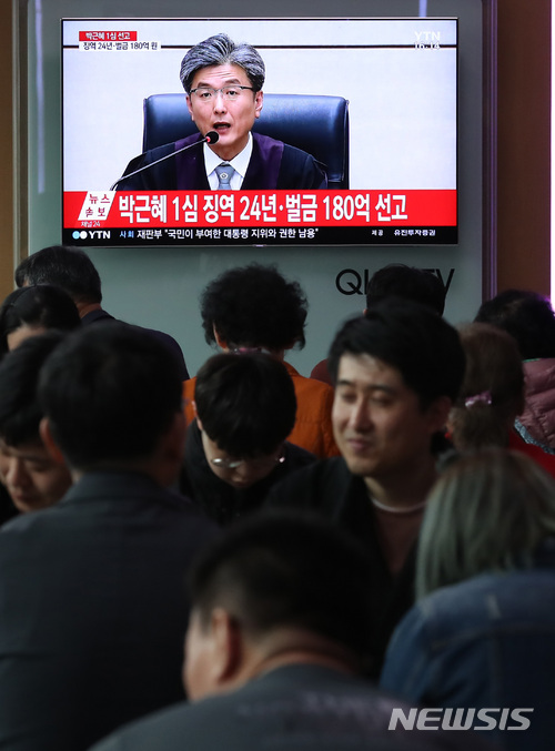 【서울=뉴시스】이영환 기자 = 박근혜 전 대통령의 국정농단 사건 1심 선고 공판이 진행중인 6일 오후 서울 용산구 서울역 대합실에서 시민들이 중계를 시청하고 있다.박근혜 전 대통령은 1심에서 징역 24년과 벌금 180억이 선고 됐다. 2018.04.06. 20hwan@newsis.com