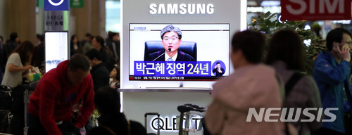 【인천공항=뉴시스】홍찬선 기자 = 박근혜 전 대통령이 국정농단 1심에서 징역 24년형을 선고 받았다. 6일 오후 인천공항 제1여객터미널 입국장에서 시민들이 TV 생중계를 주의깊게 보고 있다. 2018.04.06.&nbsp;&nbsp; mania@newsis.com