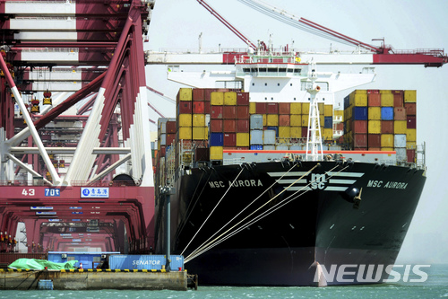 Containers are loaded onto a cargo ship at the port in Qingdao in east China's Shandong province, Friday, April 6, 2018. China vowed on Friday to fight the U.S. "at any cost" after President Donald Trump proposed slapping an additional $100 billion in tariffs on Chinese goods in an escalating trade dispute between the world's two largest economies. (Chinatopix via AP)