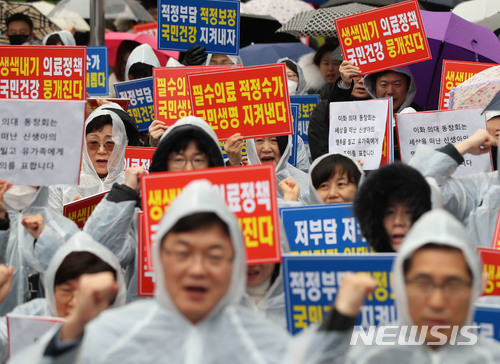 【서울=뉴시스】김진아 기자 = 8일 오후 서울 동화면세점 앞에서 열린 이대목동병원 신생아중환자실 의료진 3명 구속 규탄 집회에 참석한 대한의사협회 회원들이 문재인케어 반대 구호를 외치고 있다. 2018.04.08 bluesoda@newsis.com